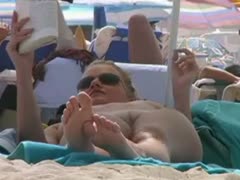 Sexy, pale-skinned whore spotted reading a book on a bare beach while dressed in natural clothing
